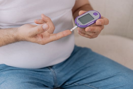 Diabetic senior man on wheelchair checking blood sugar level with fingerstick testing glucose meter. Elderly man with type 1 diabetes using blood glucose monitor at home. photo