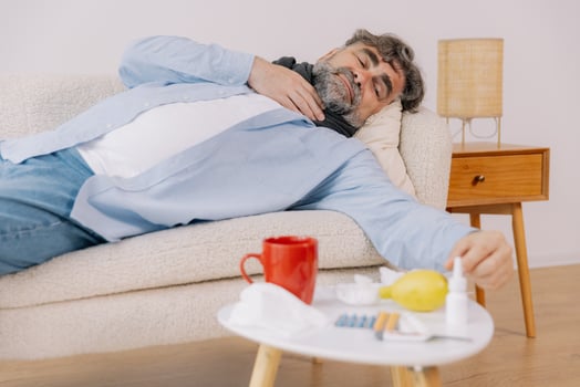Sick senior male patient lying on the couch at home photo