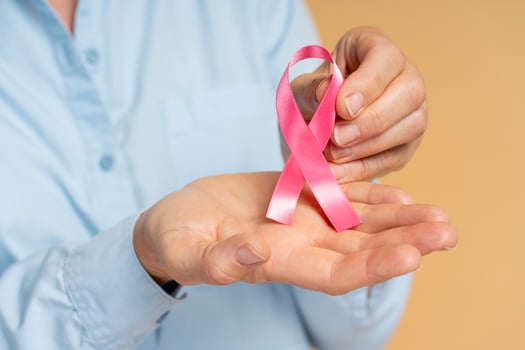 Woman holding pink ribbon showing support for breast cancer awareness photo