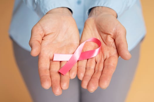 Woman showing pink ribbon supporting breast cancer awareness photo
