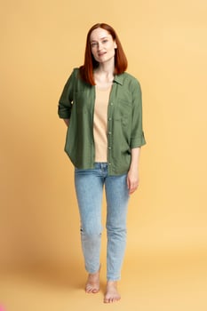 Confident woman smiling and posing on yellow background photo