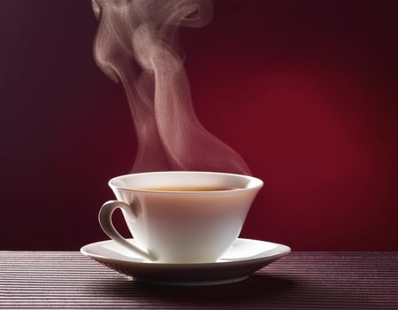 Tea cup with steam, on maroon background photo