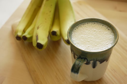 glass of milk and banana on table at morning photo