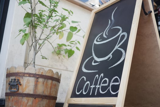 Charming Quaint Coffee Shop Sign Featuring a Beautiful Wooden Planter Displaying Plants photo