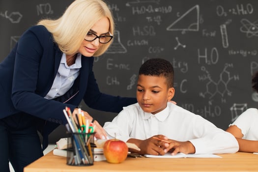 A female teacher helps a schoolboy to solve a problem. International team. Back to school. photo
