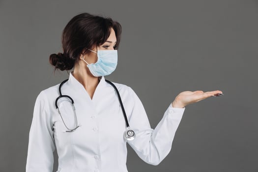 Coronavirus in Europe. Novel coronavirus 2019-nCoV, woman doctor in blue medical face mask holding hand for mockup. Concept of covid-19 quarantine photo