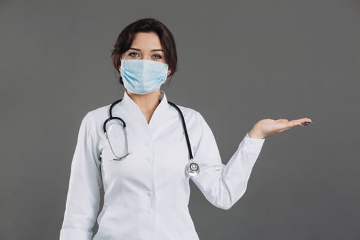 Coronavirus in Europe. Novel coronavirus 2019-nCoV, woman doctor in blue medical face mask holding hand for mockup. Concept of covid-19 quarantine photo