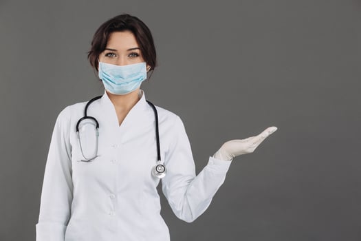 Coronavirus in Europe. Novel coronavirus 2019-nCoV, woman doctor in blue medical face mask holding hand for mockup. Concept of covid-19 quarantine photo