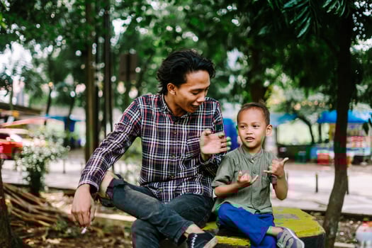 Southeast Asian father chatting with his child, capturing a moment of connection and care photo