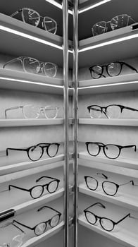 Monochrome photo of exclusive glasses displayed in a mall store.