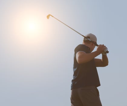Young man playing golf, golfer hitting fairway shot, swinging club photo