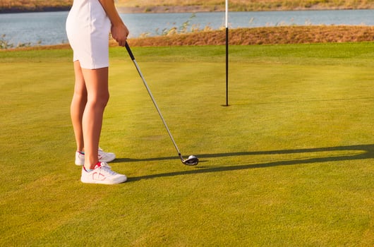 Golf player practicing to hit the ball at the course photo