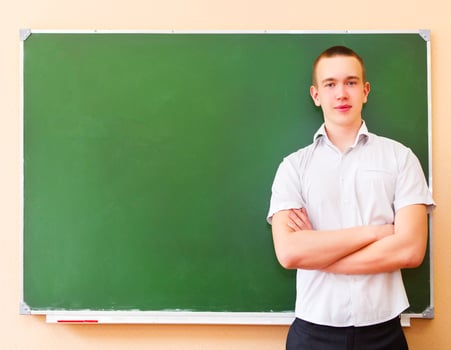 Student boy standing near the green blackboard photo