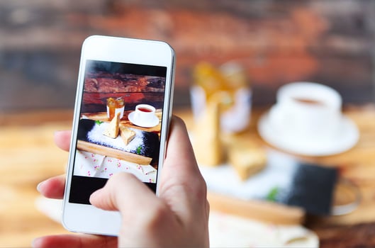Woman taking a photo of Traditional Hungarian Esterhazy cake with smartphone