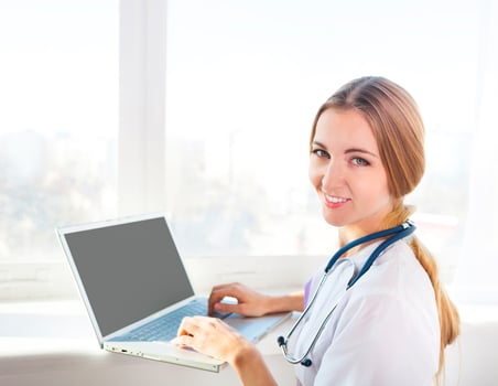 Portrait of young woman doctor at computer photo