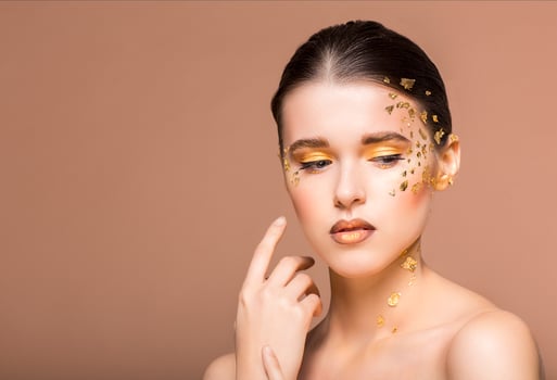 Portrait of a beautiful young woman with bright golden makeup photo