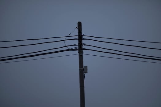 Wires on pole. Electrical wires on background of gray sky. Depressing look. photo