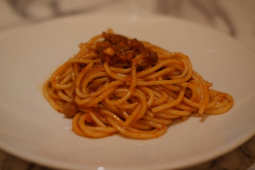 Spaghetti bolognese on a white plate in a restaurant photo
