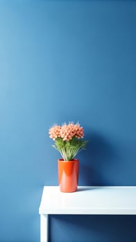 A vase of flowers on a table in front of a blue wall photo