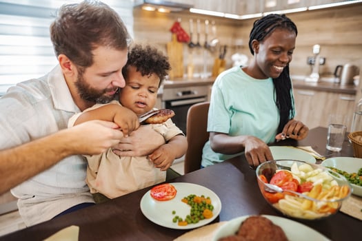 Family enjoying a meal together in a cozy kitchen at home photo