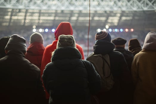 People in stadium. Lot of people are watching game. People from back. photo