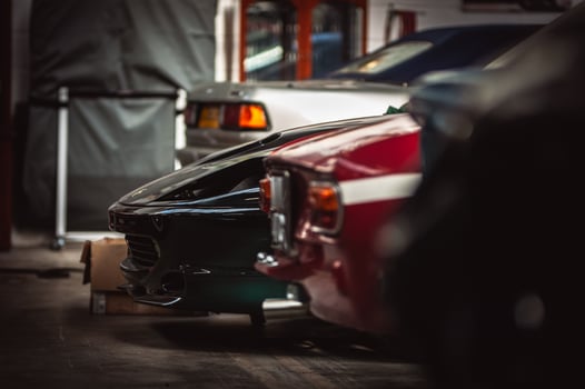 Row of cars in a garage including some classic motors. photo