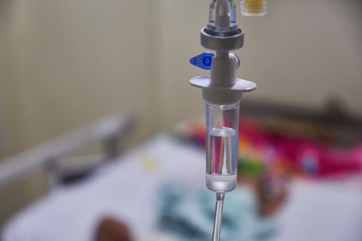 Close-up of slow iv fluid intravenous drip saline with blurred background in a hospital room, medical concept with copy space photo