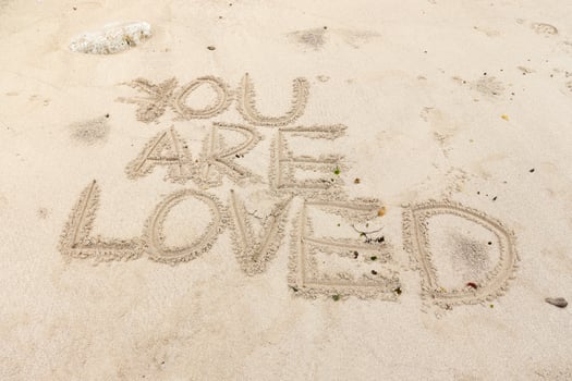 Motivation quotes You are Loved written in the sand of the beach photo
