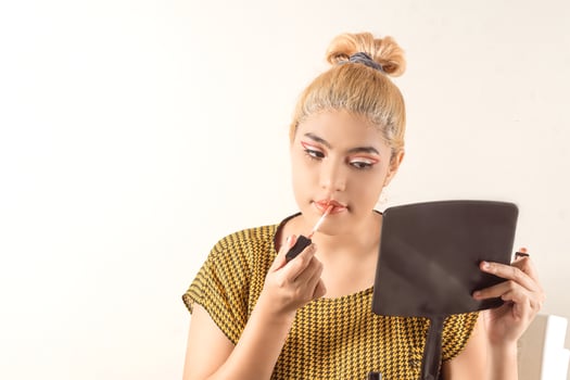 Young latin american woman doing a yourself makeup. photo