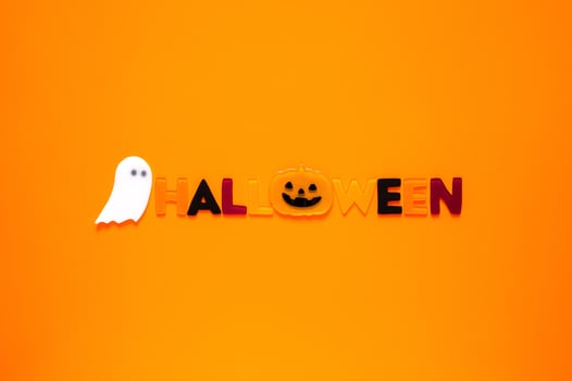 Halloween background with gel stickers of white ghost sheet and alphabets on orange background. Minimal concept. photo