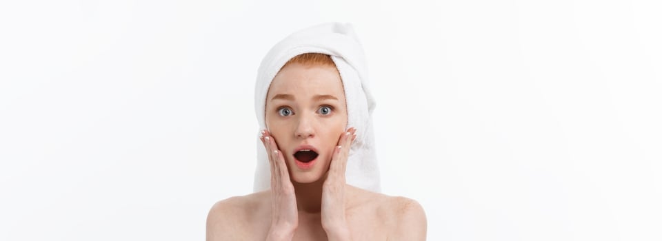 Surprised Beautiful Young Woman After Bath with A Towel On Her Head Isolated On white Background. Skin Care And Spa Theme. photo