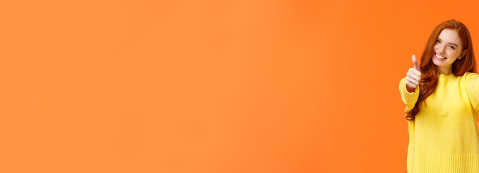 Good luck. Optimistic, confident cute redhead girlfriend encourage you, giving thumbs-up in like or approval, smiling rate excellent movie or product, give positive feedback, recomment, orange wall photo