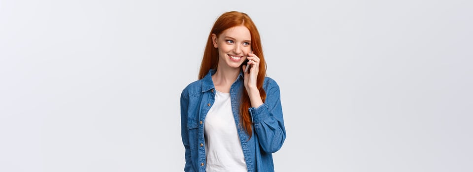 Girl calling boyfriend pick her up after classes. Attractive outgoing redhead woman talking on phone, smiling carefree, look away as having casual conversation on smartphone, white background photo