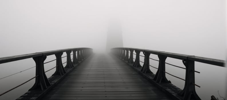 A dimly lit bridge amidst the foggy landscape photo