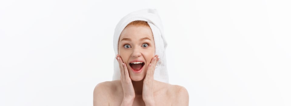 Surprised Beautiful Young Woman After Bath with A Towel On Her Head Isolated On white Background. Skin Care And Spa Theme. photo