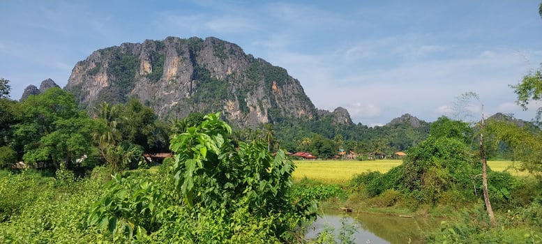 Scenic view of lush green mountains with a clear blue sky and fields in the foreground, showcasing natural beauty and tranquility. photo