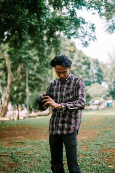 Southeast Asian man looking into his wallet, expressing concern or curiosity about finances photo