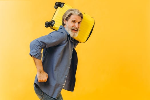 Stylish laughing bearded man holding a yellow suitcase. photo