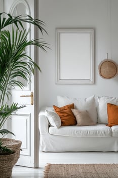 White sofa with orange pillows is placed near a door in a well-lit living room photo