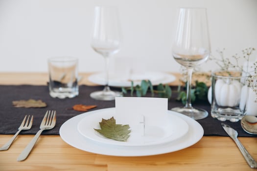 Thanksgiving table setting, tableware and decorations. Blank white postcard on table mockup. photo