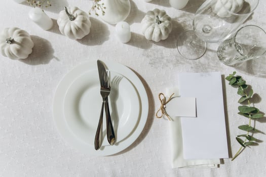 Thanksgiving table setting, tableware and decorations. Blank white postcard on table mockup, top view photo