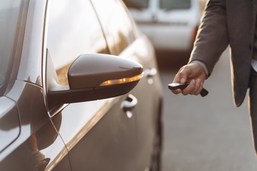 A male hand opens the car with a car key fob photo