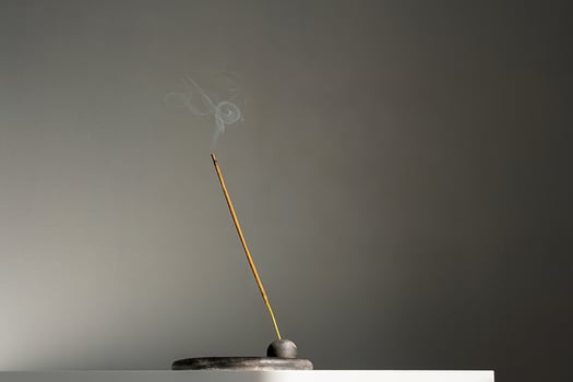 Burning incense stick and smoke with contrast shadows. photo