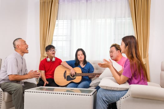 Asian family, Senior man and grandchild having fun together while singing and playing the guitar in living room at home photo