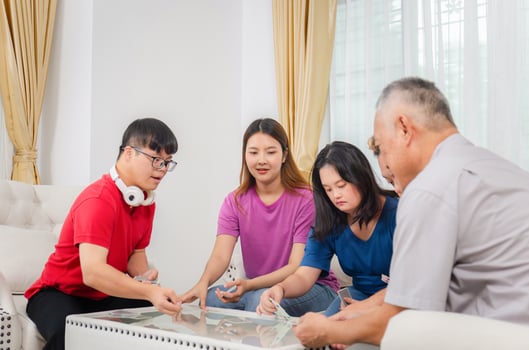 Senior man and grandchild relaxing in living room, Grandchild interacting with friends and playing cards with grandparents at home, Asian family photo