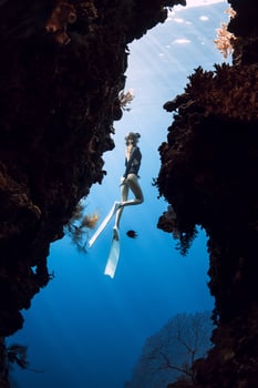 Woman freediver glides in underwater cave on Menjangan island, Bali. photo