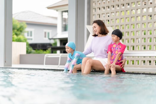 Happy kids girl playing and having fun in swimming pool, Asian mother and daughter enjoy outdoor activity at pool photo
