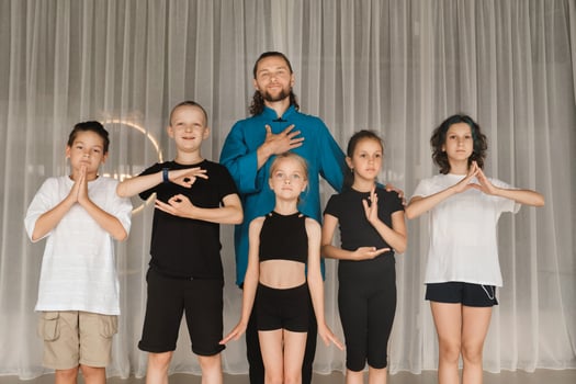 A joint portrait of a yoga coach and children standing in a fitness room photo