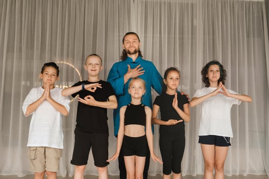 A joint portrait of a yoga coach and children standing in a fitness room photo