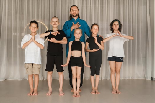A joint portrait of a yoga coach and children standing in a fitness room photo